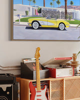 A stylish mid-century room with artwork of a 50's convertible parked outside a Palm Springs home, a nod to "Don't Worry Darling".