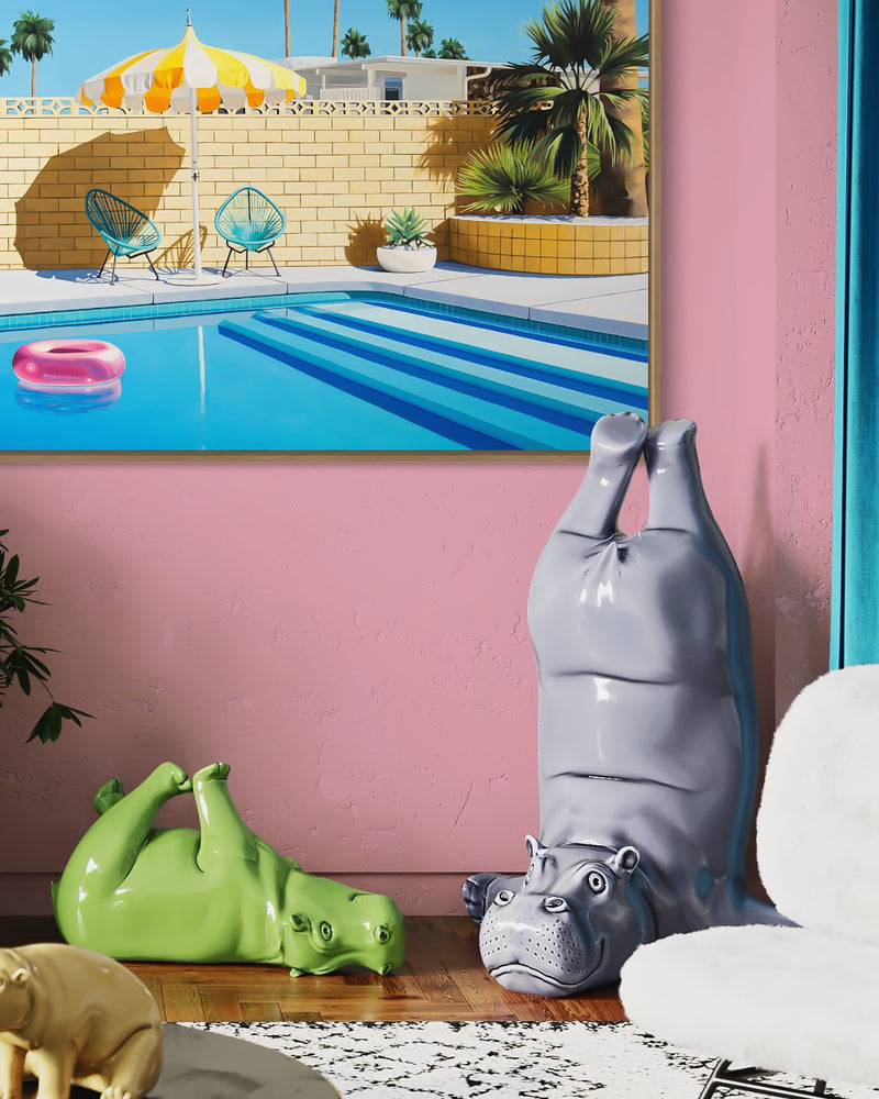 Relaxation awaits in a sparkling blue pool, complete with a pink inflatable pool ring and a yellow and white striped umbrella on a warm summer day in Palm Springs.