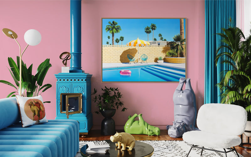 artwork depicting a vibrant pink pool ring and a stylish yellow and white striped umbrella in a beautiful Palm Springs setting.