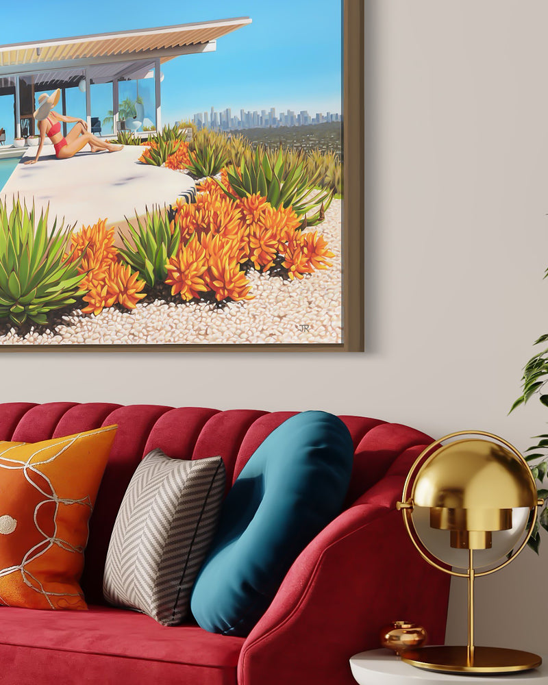 A beautiful and serene living space featuring a stunning artwork of a woman enjoying the warmth of the sun by the poolside, while admiring the mesmerizing Los Angeles skyline in the background