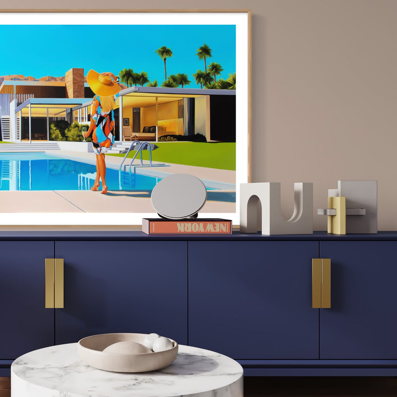 Chic mid-century room with Kaufmann house artwork. Woman lounges poolside in wide-brimmed floppy hat