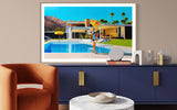 Artwork of Kaufmann house & a new take on Slim Aarons Poolside Gossip add style to mid-century room. Woman in floppy hat lounges poolside on sunny day.