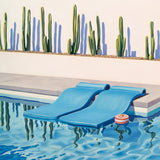 The cool blue of the swimming pool beckons, framed by stylishly arranged pool floats in a Palm Springs paradise