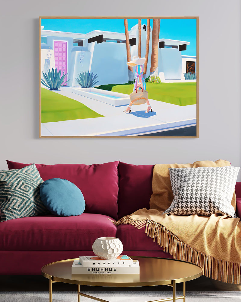 A pop of color in the desert: A woman in a bright dress stands in front of a hot pink door, adding a burst of color to the dry desert landscape